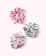 Top-down view of the Pusheen Hair Scrunchys. The circular hair bands have three unique Pusheen patterns printed on the light pink, mint green, and white hair scrunchies.  