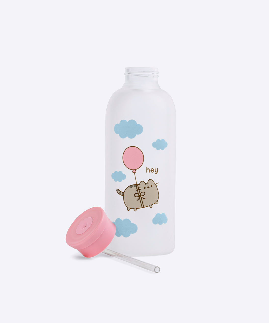 Glass water bottle stands on a white surface with the included pink top lid and plastic straw lying next to the bottle. 