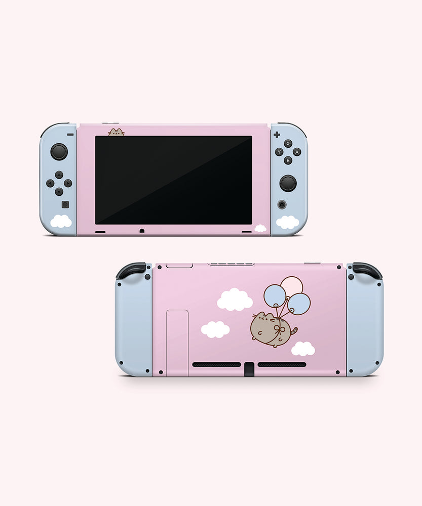 Front and back view of the Pusheen Balloons decal for a Nintendo Switch OLED. The front side is a two-toned light pink and light blue colors with a Pusheen graphic and white fluffy clouds. The back has blue joy stick stickers and a pink middle background with white fluffy clouds and a graphic of Pusheen in the middle of the decal being carried by three balloons.