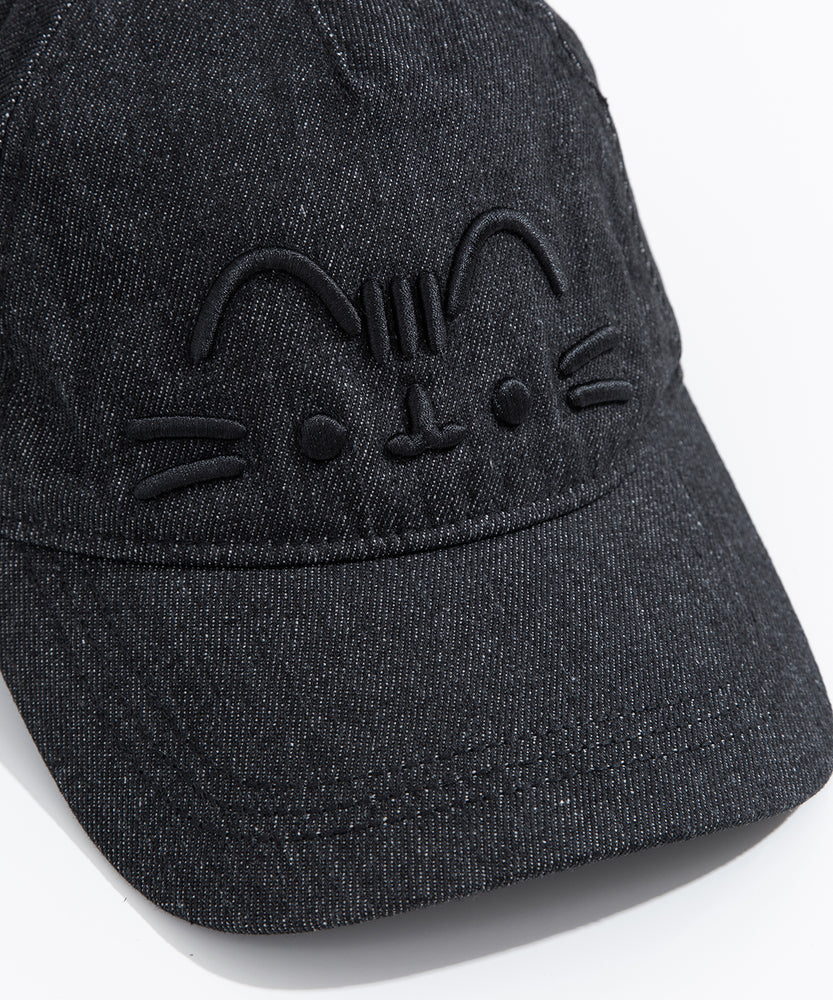 Close up view of embroidered graphic on the front center of the baseball style cap. Pusheen the Cat’s head stripes, ears, eyes, mouth and whiskers are shown in black embroidered thread. 