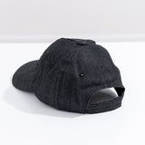 Back view of the charcoal-colored hat. The baseball style cap has a top button, eyelet holes for head ventilation, and an adjustable Velcro strap on the back for customized fit. 