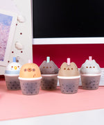 Five bubble tea cup squishy toys with cat, sloth, and bird faces on the top of the cup portion.