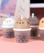 Close-up of Bubble Tea Squishy Toy. The boba tea cup's top half is of Pusheen's head with a straw between her two gray ears. 