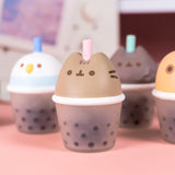 Close-up of Bubble Tea Squishy Toy. The boba tea cup's top half is of Pusheen's head with a straw between her two gray ears. 