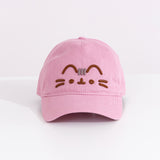 Front view of the pink Pusheen Cap. The light mauve baseball-style hat has Pusheen the Cat’s face embroidered in a 3D effect. The brown and grey thread is on the front center of the cap. 