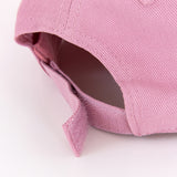 Close-up view of the Velcro strap on the back of the cap. The Velcro, hat seams, and eyelet embroidery matches the pink hat color. 
