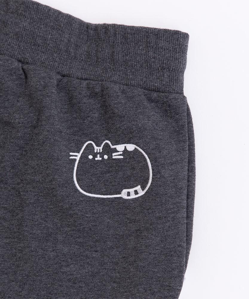 Close-up of the embroidered Pusheen graphic on wearer's back hip. The embroidery thread color is white and shows Pusheen lying down.