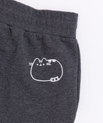 Close-up of the embroidered Pusheen graphic on wearer's back hip. The embroidery thread color is white and shows Pusheen lying down.