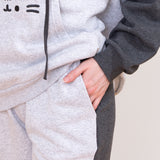 Close-up view of a model wearing the Pusheen set. The model has their hand in the side pocket. The two-toned of the sweatshirt and joggers can be seen in this image.