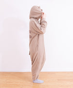 Model faces to the side while wearing the Pusheen Kigurumi Onesie. The model holds up the hood with their hands so that the felt ears can be seen sticking up. In this view, the back stripes and tail details can be seen. 