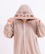 A model wearing the Pusheen Classic Kigurumi with their head facing downwards to show off the brown and grey embroiderred details of Pusheen’s face and ears on the kigurumi’s hood. 