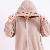 A model wearing the Pusheen Classic Kigurumi with their head facing downwards to show off the brown and grey embroiderred details of Pusheen’s face and ears on the kigurumi’s hood. 