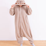 Model wearing the Pusheen Classic Unisex Kigurumi with their hands holding the hood over their head. The grey and brown traditional kigurumi onesie is baggy with the front zipper ending near the wearer's calves.