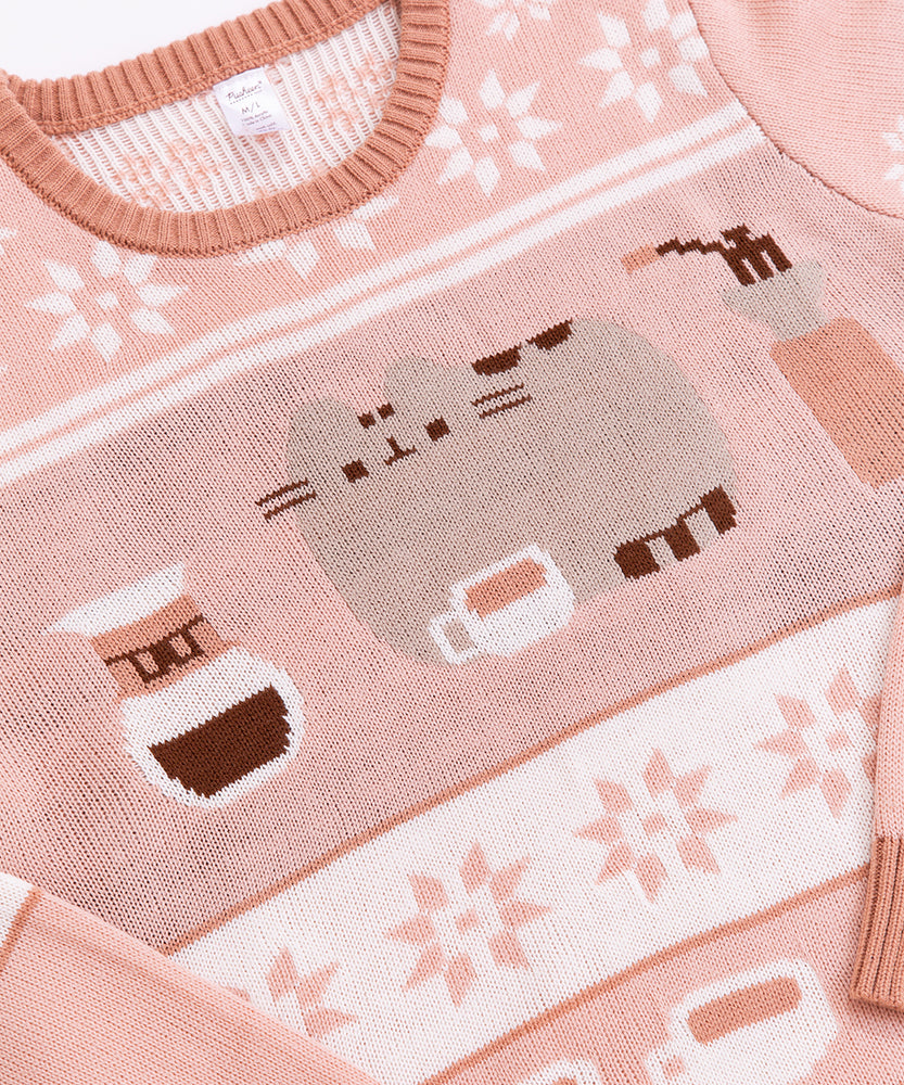 Close-up of the front knit pattern on the Coffee-themed Pusheen Sweater. The grey cat is lying next to a coffee mug, a drip coffee maker, and coffee grinder. 