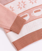 Close-up of the ribbing detail at the cuffs and bottom hem of the knit seater. The brown color matches the knit color shown in the repeating pattern near the sweater's hem.