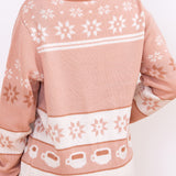 Model showing off back design of the knit sweater. The star motifs and coffee cup patterns continue around the back of the sweater.