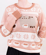 Model wears the Pusheen Knit Sweater. The knit sweater features repeating patterns of white and brown star motifs on the top, middle, and sleeves of the sweater.