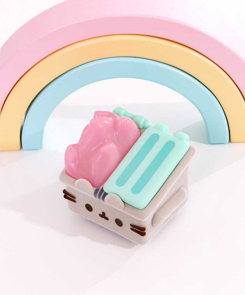 Top view of the Pusheen trash figurine. The dumpster has two mint green lids, one of which is open to reveal the pastel pink flames shooting out the top of the figure.  