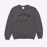 A charcoal grey sweatshirt with sleeves folded out to the side against a white background. The unisex sweatshirt has an embroidered graphic of a classic Pusheen the Cat on the center of the chest in black. The Pusheen sweatshirt also has a heart outline embroidered in black thread on the wearer’s left sleeve near the cuff. 