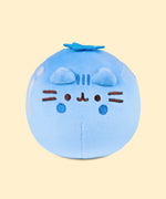 Front view of the Pusheen Fruits Blueberry Squisheen Plush. The blue plush stands 4” tall and has Pusheen the Cat’s facial features embroidered on the front of the round form in dark brown and dark dark. Coming off the top of the plush is a darker blue felt calyx. 