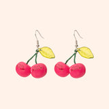 Cherry drop earrings turned to the side to show the shine of the plastic earrings. The dangle earrings include stainless-steel silver earring hooks.  