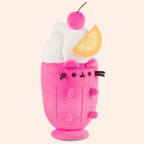Right quarter view of the medium sized plush. The felt orange slice sits off the middle and top portion of the plush. Pusheen's ears and four paws extend off the body of the drink container portion of the plush. 