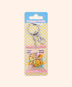 Pusheen Fruits Keyring in its packaging. The keyring is attached to a cardboard backer card that features a yellow and white checkered print and a blue hanger.