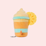 Back view of the Pusheen Fruits Pineapple Float Plush. Pusheen's striped tail extends off the back of the drink-inspired plush. The cylinder base is topped with a fuzzy whipped plush topping and a two-toned pineapple slice.