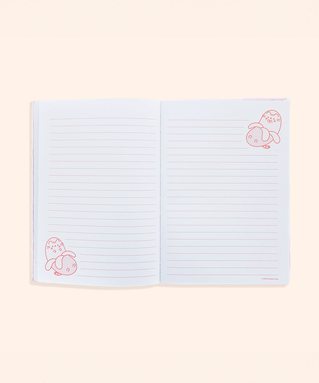 Interior view of pink banana notebook. On the white pages are light pink writing lines and pink graphics of Pusheen as a banana in both the bottom left corner and top right corner of the opened pages.