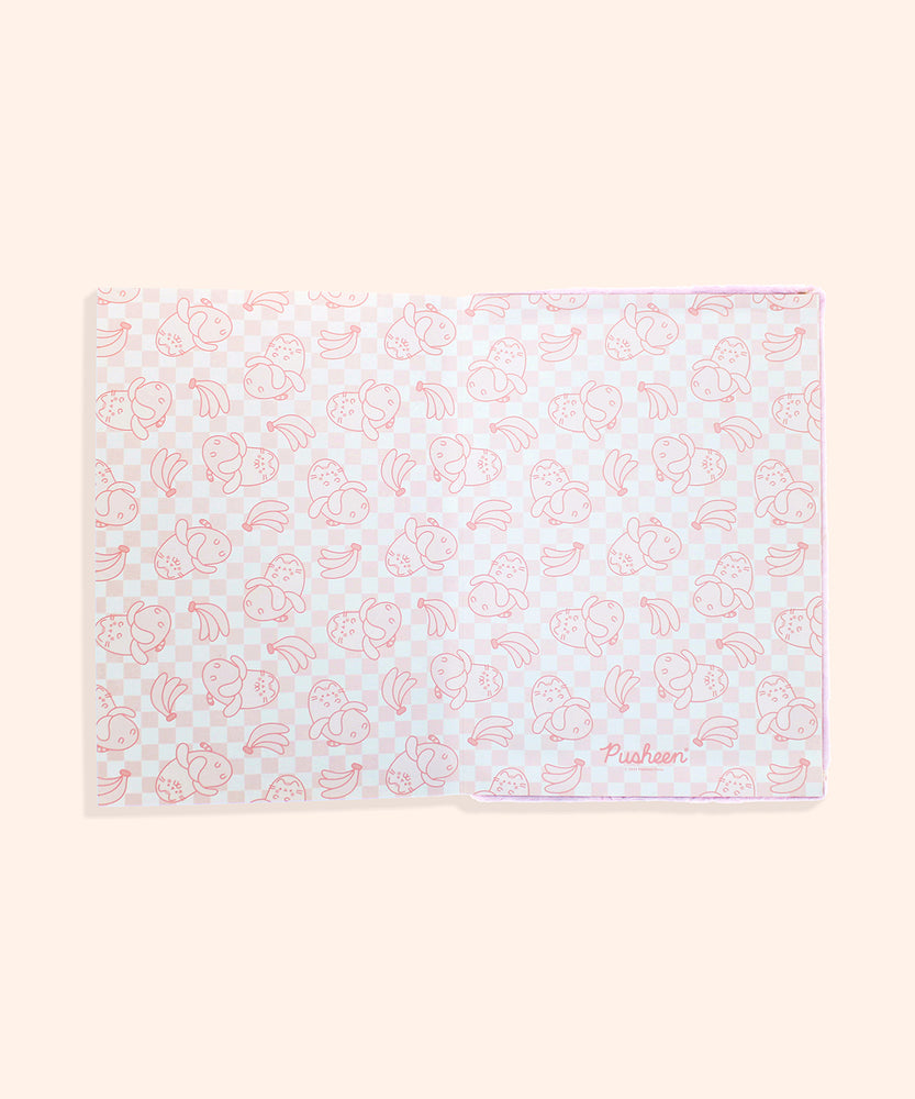 Interior view of the plush notebook. The inside cover features a pink checkered print with bananas and Pusheen Bananas in a scattered pattern.