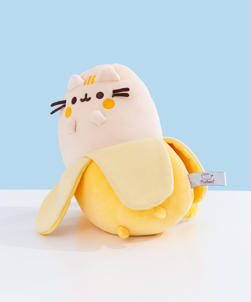 Quarter side view of the two-toned yellow Pusheen plush. The plush shows Pusheen the Cat as a banana with its peel halfway down to expose the fruit.