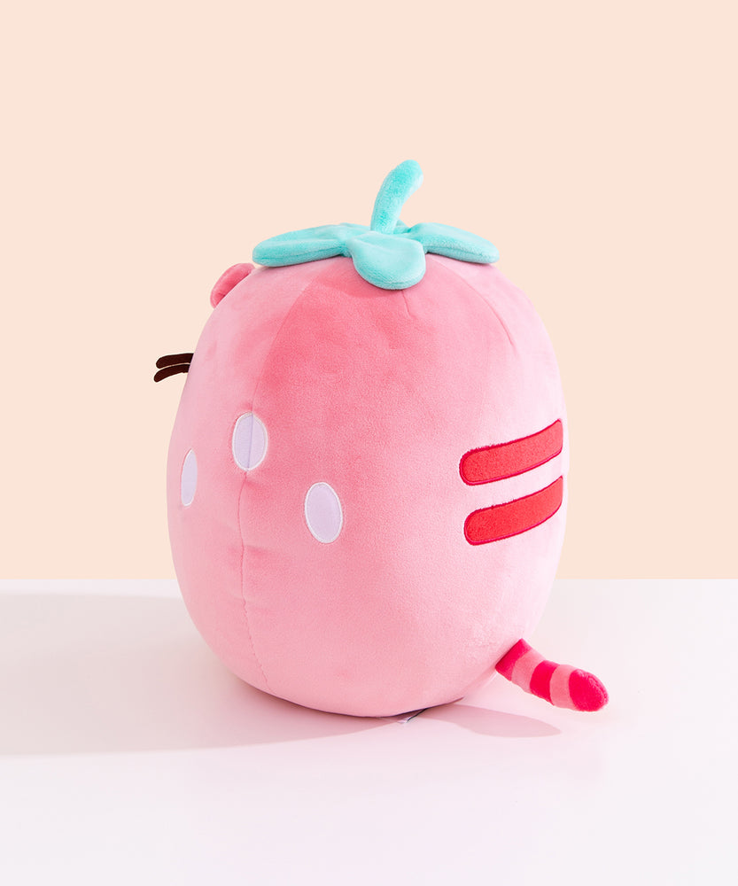 Side and back view of the Pusheen Fruits Scented Strawberry Squisheen Plush. On one side is three white circles to mimic strawberry seeds.