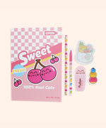Contents of the Pusheen stationery set in front of a light green background. The set includes a pink notebook, printed pencil, ballpoint pen, highlighter, sticky notes, and an eraser.