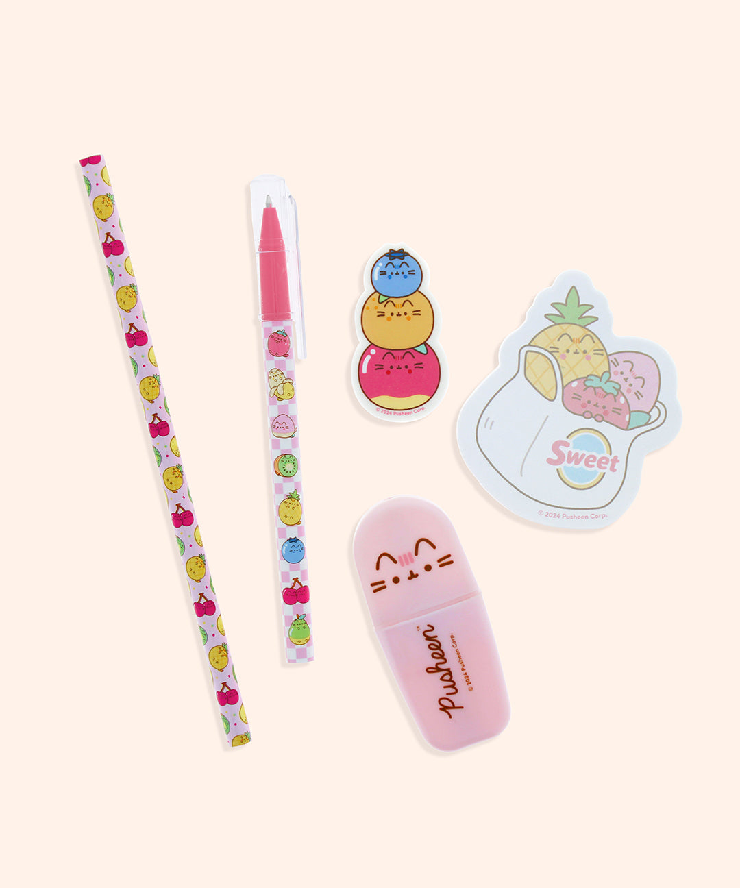 Close-up view of the contents of the Pusheen Fruits Stationery set. The pencil, pen, sticky notes, eraser, and highlighter include graphics and prints of Pusheen the Cat as various Fruit characters including a pineapple, cherries, kiwi, pear, blueberry, pear, banana, strawberry, orange, and apple.