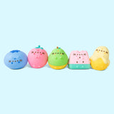 Line up of the Pusheen Fruits Surprise Squishy. From left to right is a blueberry, strawberry, pear, watermelon slice, and partially-peeled banana.