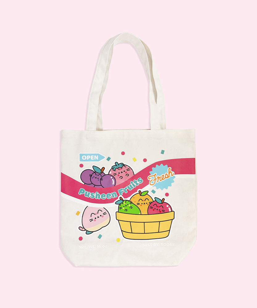 Front view of graphic on the Pusheen Frutis Tote Bag. The cream-colored canvas tote features various Pusheen Fruits characters including grapes, strawberry, peach, pear, orange, and apple. Phrases printed on the tote include "open," "Pusheen Fruits," and "Fresh."