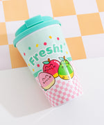 The travel mug lies on its front to show the printed back graphic. The graphic includes three Pusheen Fruits characters including a green and brown kiwi slice, a checkered yellow pineapple, and a set of red cherries on stems.  
