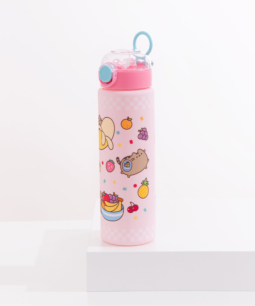 Front view of the Pusheen Fruits Water Bottle. The pink bottle features a clear pop-top lid activated by a blue button, a light blue carrying ring, and a light pink base with white checkered corders and multi-colored Pusheen Fruits graphics.