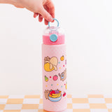 Model holding the light blue carrying ring of the Pusheen Fruits Water Bottle. Some of the graphics printed all around the light pink bottle are Pusheen hiding behind a yellow banana, Pusheen next to a fruit bowl, and Pusheen with a banana stickers on her side.