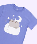 A close-up view of the screen printed graphic on the Pusheen Good Night Unisex Tee. In the graphic, the grey tabby cat is napping on a white marshmallow surrounded by dreamy details including a moon, stars, and ZZ's. 