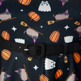 Close-up of the allover pattern of the Pusheen Halloween Dress. A grey Pusheen wearing a purple hat rides on a broomstick next to a white Ghostsheen. Surrounding the characters are orange pumpkins and white sparkles.  
