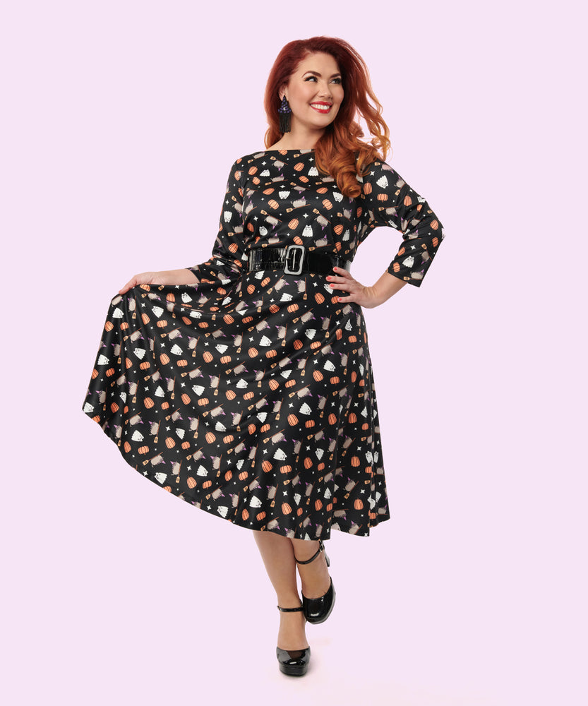 Alternate model shows off the print of the Pusheen Halloween Dress by holding the skirt out to her right side. The pattern extends from the boat neckline to the dress hem. 