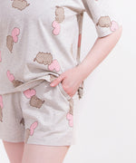 A close-up view of the Pusheen drawstring pajama shorts. The shorts have an elastic band for a cozy fit. The model has their hands in their pocket to show off the side pocket features of the shorts. 
