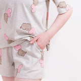 A close-up view of the Pusheen drawstring pajama shorts. The shorts have an elastic band for a cozy fit. The model has their hands in their pocket to show off the side pocket features of the shorts. 