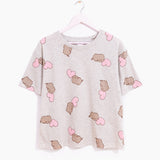 Hung on a white hanger, the Pusheen Pajama Tee is hung out to show the full length of the oversized t-shirt. The gray tee has printed all over graphic of Pusheen and pink hearts. 