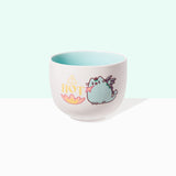 A white ramen bowl with a light blue/teal interior color. The Dragonsheen graphic features the colors teal, purple, pink, yellow, and dark purple. Dragonsheen Pusheen can breathe fire and she has two small wings and a forked tail.
