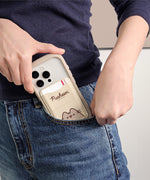 Model places a phone in their pocket that has the Pusheen Magnetic Phone Wallet attached to the back. The beige case is slim enough to fit in pockets easily and strong enough that the wallet will not fall off the phone. 