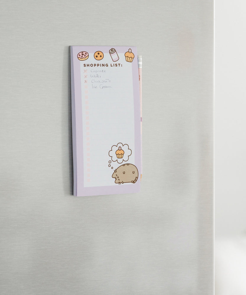 Back view of the Pusheen Magnetic Shopping List Notepad. The pink and purple cardboard backer card has two magnetic strips to ensure a strong hold. One magnet is near the top of the rectangular notepad while one magnet is near the bottom. 