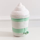 Back view of the Pusheen Matcha Plush. Pusheen's striped tail extends off the back of the drink-inspired plush. The cylinder base is topped with a fuzzy whipped plush topping.