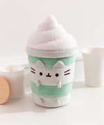 Matcha Latte-inspired Cat plush surrounded by desk items such as a candle and coffee cup.